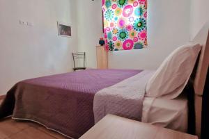 um quarto com uma cama roxa e uma janela em Casa Vacanze Margherita em Caltagirone