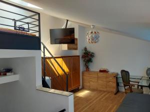 uma sala de estar com uma escada e um quarto com uma televisão em 3 seperate APARTMENTS - 1,5 room apt - 2,5 rooms apt - 3,5 rooms apt mit sauna and kamin em Munique