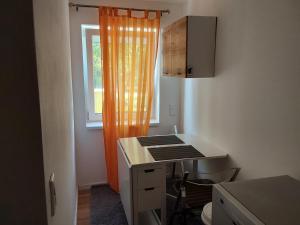 3 seperate APARTMENTS - 1,5 room apt - 2,5 rooms apt - 3,5 rooms apt mit sauna and kamin في ميونخ: مطبخ وستارة برتقالية ونافذة