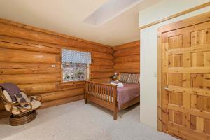 a bedroom with a bed and a window and a door at Bear Ridge Cabin in Leavenworth