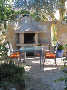 a patio with a table and two chairs and a stone fireplace at Ferienoase ENGEL in Überlingen
