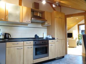 a kitchen with wooden cabinets and a stove top oven at Ferienoase ENGEL in Überlingen