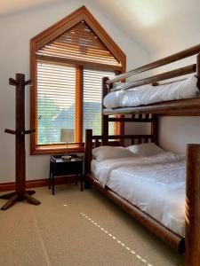 1 Schlafzimmer mit 2 Etagenbetten und einem Fenster in der Unterkunft Beautiful Cottage at The Blue Mountain in Blue Mountains