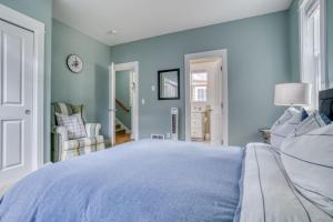 a blue bedroom with a bed and a chair at Mertini in Depoe Bay