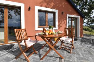 a wooden table and two chairs on a patio at Dadaj Park Home in Biskupiec