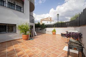 a courtyard of a house with potted plants at Amplio apartamento para corta o larga estancia in Cájar