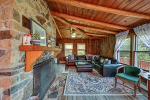 a living room with a stone wall with a fireplace at Oceanfront Milbridge Getaway with Deck and Views! in Milbridge