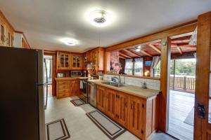 a kitchen with wooden cabinets and a refrigerator at Oceanfront Milbridge Getaway with Deck and Views! in Milbridge