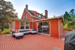 an orange house with a deck with a couch at Oceanfront Milbridge Getaway with Deck and Views! in Milbridge