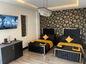 a bedroom with two beds and a wall with a picture at RESIDENCY LUXURY SEAFRONT HOTEL in Blackpool