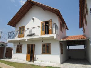 a large white house with a balcony at Casa 1 Chalé Alto dos Bandeirantes in Tiradentes