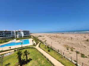 uma vista para a praia a partir da varanda de um resort em Sidi Rahal Blue View, Piscine & mer sans vis-à-vis em Sidi Rahal