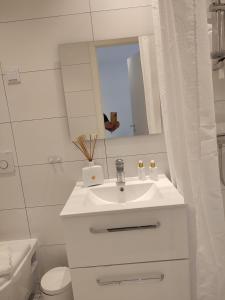 a white bathroom with a sink and a mirror at Göteborgs Pärla in Gothenburg