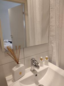 a bathroom sink with a mirror and a vase on it at Göteborgs Pärla in Gothenburg