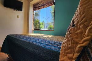 a bedroom with a bed with a large window at Casa elegante y con terraza in Arequipa