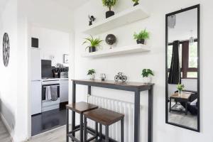 una pequeña cocina con mesa y espejo en The Mayfield Apartment, en Londres