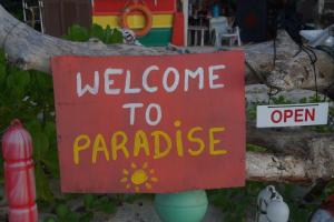a red sign that says welcome to paradise at Redang Campstay in Redang Island