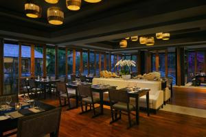 uma sala de jantar com mesas, cadeiras e janelas em Amarterra Villas Resort Bali Nusa Dua, Autograph Collection em Nusa Dua