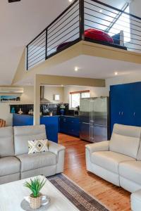 a living room with two couches and a kitchen at Tyrone Sands Rye in Rye