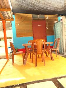una mesa de madera y sillas en un patio en Bedrooms where Charlie en El Paredón Buena Vista