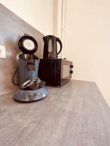 d'une cafetière et d'une horloge sur un comptoir. dans l'établissement Studio de la Belle Vue, à Charleville-Mézières