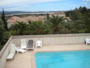 a swimming pool with two chairs and avisorvisor at Le Fenouillet Chambres D'hotes proche des Grands Buffets in Narbonne