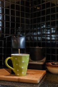 uma cafeteira e uma chávena numa tábua de cortar em Tyrone Sands Rye em Rye