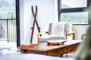 a living room with a chair and skis on the wall at Revy's Stellar Retreat in Revelstoke