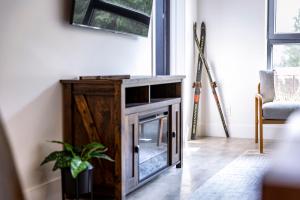 a living room with a fireplace in a wooden cabinet at Revy's Stellar Retreat in Revelstoke +28 photos