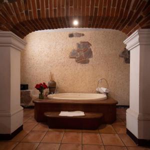 Habitación con baño grande con bañera. en Hotel Real Plaza, en Antigua Guatemala