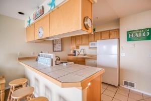 a kitchen with a white refrigerator and wooden cabinets at Waters Edge 407 in Lincoln City