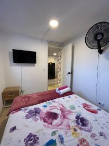 ein Schlafzimmer mit einem Bett mit Blumenmuster darauf in der Unterkunft Jardín de Florida Apto in Medellín