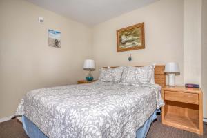 a small bedroom with a bed and two lamps at Waters Edge 407 in Lincoln City