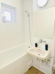 een witte badkamer met een wastafel en een spiegel bij Nono's apartament in Cluj-Napoca