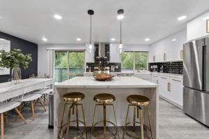 a kitchen with a large island with bar stools at NEW Fully Remodeled, Updated 8 beds, 3 baths High End Modern Home Private WaterFront in Kirkland