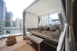 a balcony with a couch and a large window at Hound Hotel Minam in Busan