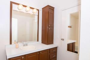 a bathroom with a sink and a mirror at HERITAGE HOUSE GREAT FOR GROUPS!!! in Pahrump