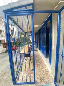 Apartaestudio Santa Rosa de Cabal Calle 16B # 7-30 ALTOS DE LOS LAURELES - ESQUINA في سانتا روزا دي كابال: بوابة زرقاء مع كرسي في مبنى