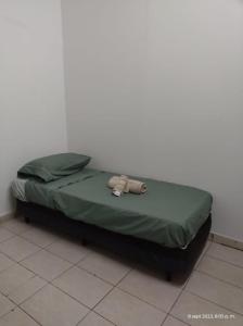 Una cama con un edredón verde sobre el suelo. en Depto Lavalle, en San Luis