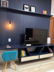 a black desk with a tv and a blue chair at Casa Almirante Premium in Macapá