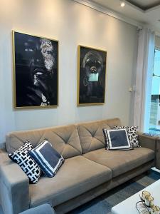 sala de estar con sofá marrón y 2 fotografías en Casa Almirante Premium, en Macapá