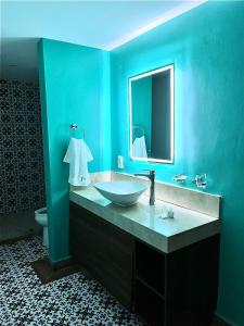 ein blaues Badezimmer mit einem Waschbecken und einem Spiegel in der Unterkunft Rincon de Hidalgo in San Juan del Río