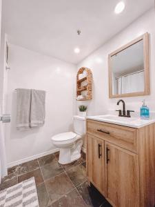 a bathroom with a toilet and a sink and a mirror at Modern Studio - Heart of Waikiki with Parking! in Honolulu