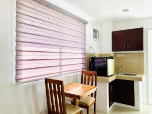 a kitchen with a table and two chairs and a window at Crosswinds Hotel in Manila