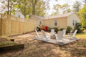 a backyard with white chairs and a wooden fence at Industrial Chic Getaway Simpsonville - Family Home in Simpsonville
