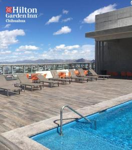 a swimming pool on the roof of a building at Hilton Garden Inn Chihuahua in Chihuahua