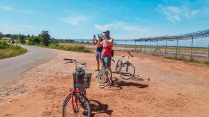 two people standing next to bikes on a dirt road at Sok Phen Homestay in Siem Reap