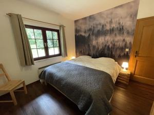 een slaapkamer met een bed en een schilderij aan de muur bij Ardennes villa with riverside garden and views in Atzerath