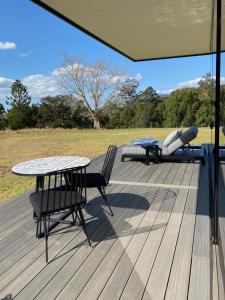 a deck with a table and chairs and a picnic table at Avion Retreat in Pumpenbill
