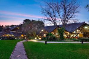 ein großes Gebäude mit grünem Rasen davor in der Unterkunft Protea Hotel by Marriott Lusaka Safari Lodge in Chisamba
